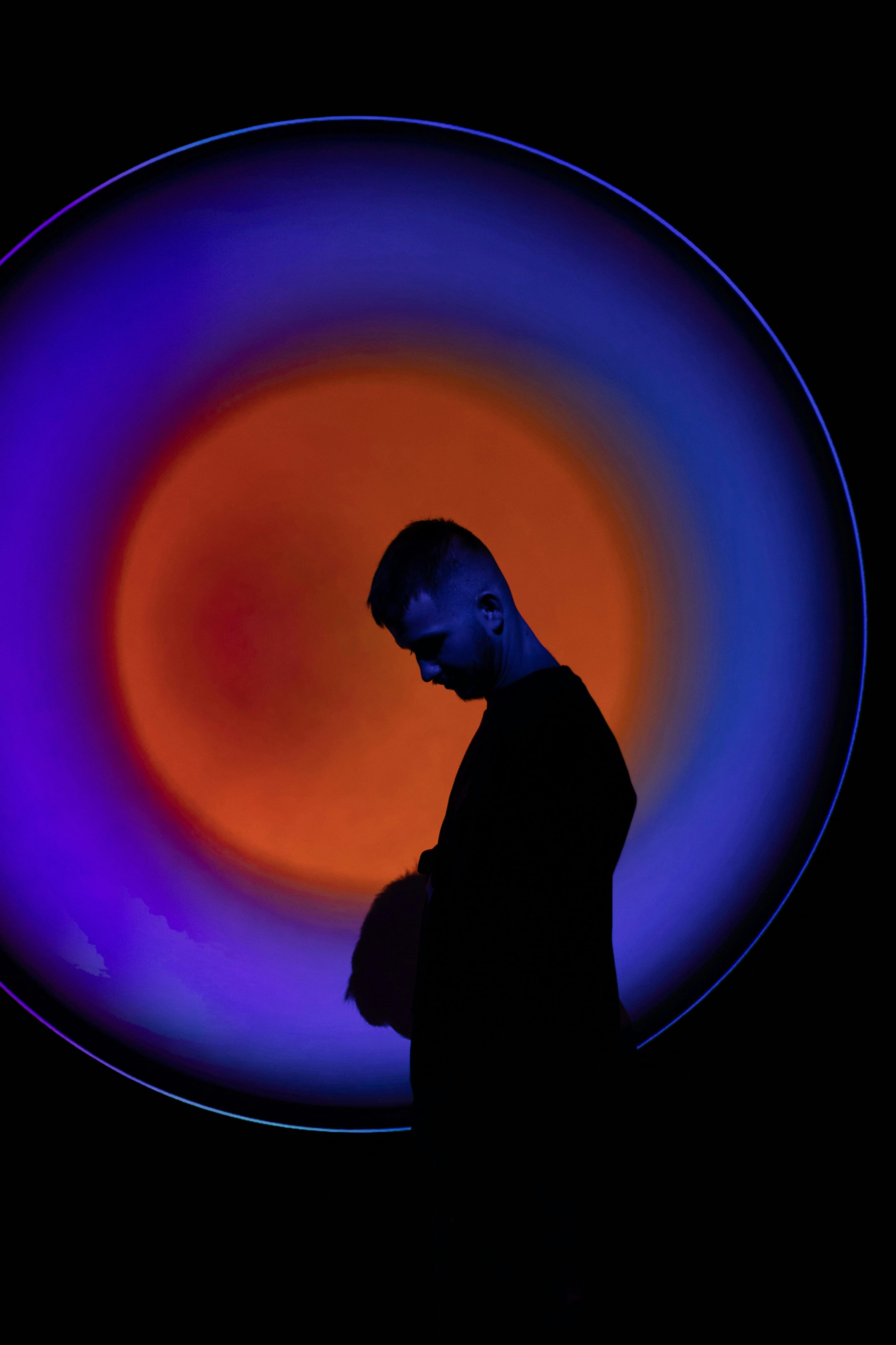 A man standing in front of a large circular light